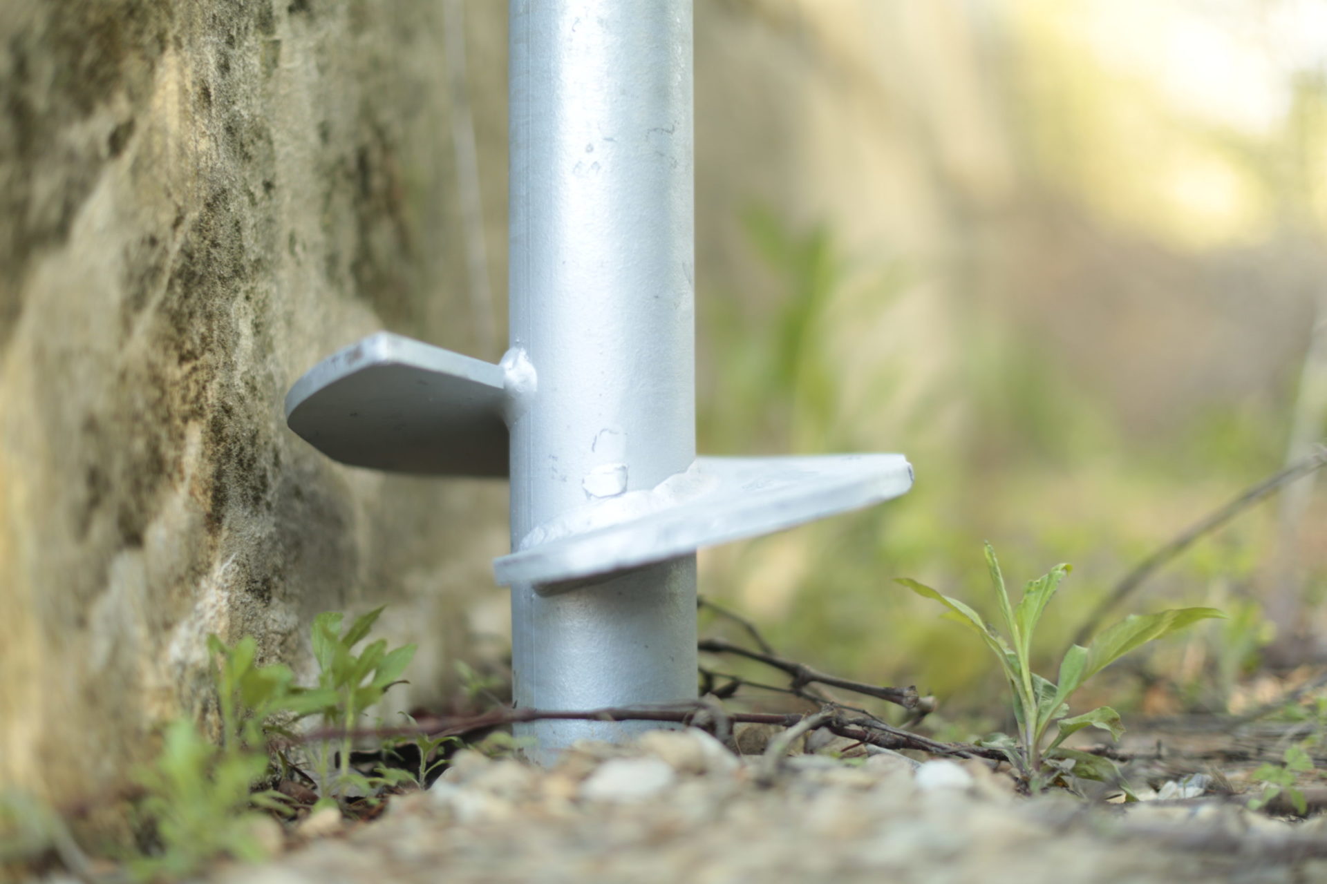 Close-up of a helical pier in the soil.